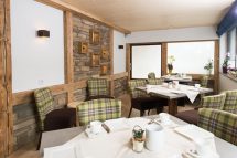 Gemütlicher Speisesaal in der Pension Annemarie mit rustikalem Holzdesign und einladenden Sitzplätzen.
