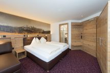 Gemütliches Zimmer mit Doppelbett und Holzdetails in der Pension Annemarie, Saalbach Hinterglemm.