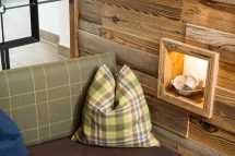 Gemütliche Kissen in einer Holzverkleidung mit sanfter Beleuchtung in der Pension Annemarie.