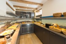 Moderne Küche der Pension Annemarie mit Buffet und alpine Landschaftsdekor.