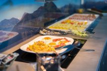 Herzhaftes Frühstück mit Rührei, Speck und frischen Zutaten in der Pension Annemarie.