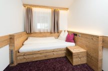 Gemütliches Zimmer in der Pension Annemarie mit Holzinterieur und neutralen Farben.