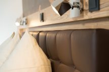 Gemütliches Bett mit Kissen und stilvollem Kopfteil in der Pension Annemarie.